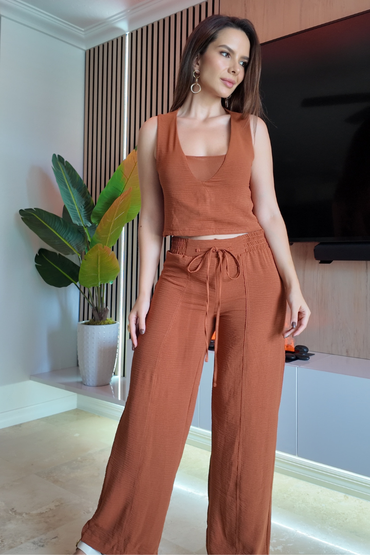 Mujer modelando set blusa Aroa y pantalón Alaia color terracota. Blusa crop sin mangas y pantalón ancho con cordón, conjunto femenino. Moda mujer.