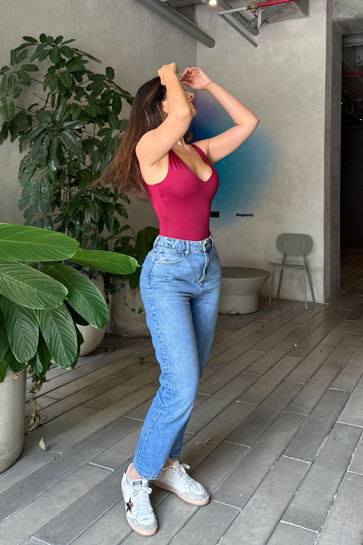 Modelo usa body Ryna Vino y jeans, resaltando su estilo versátil. Diseño cómodo y empoderador hecho en Colombia.