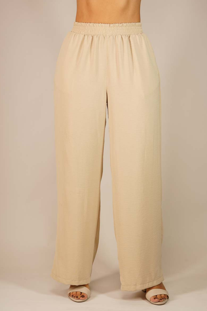 Pantalón Brena arena de seda Moma, cómodo y elegante, con pretina elástica. Pernera ancha, ideal para looks casuales y de noche.