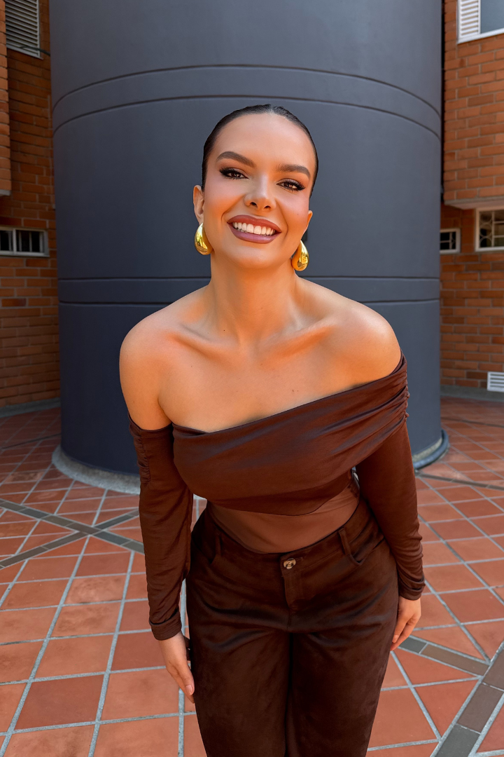 Body Aria Marrón de manga larga, cuello barco, hombros descubiertos, en modelo sonriendo, ideal para realzar la figura.