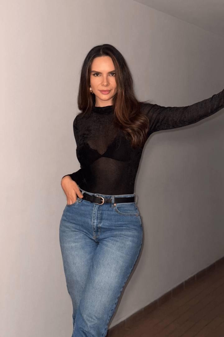 Modelo usando body Brisa negro afelpado, manga larga, cuello alto y translúcido con jeans.