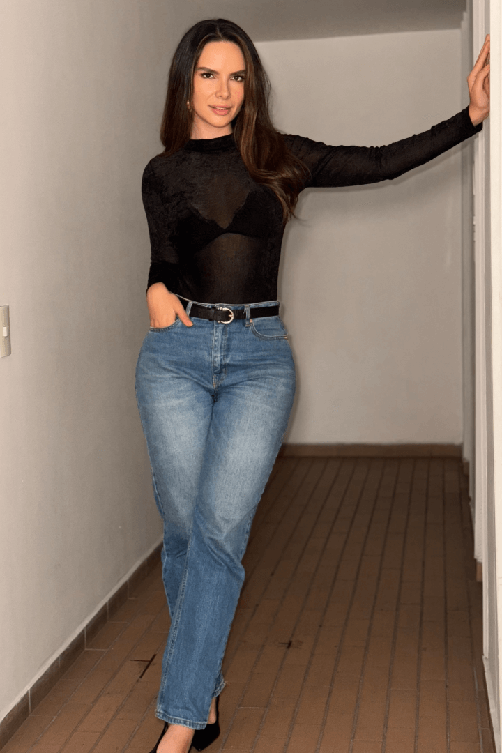 Body Brisa Negro afelpado manga larga, cuello alto, con tela translúcida sobre jeans y tacones negros.