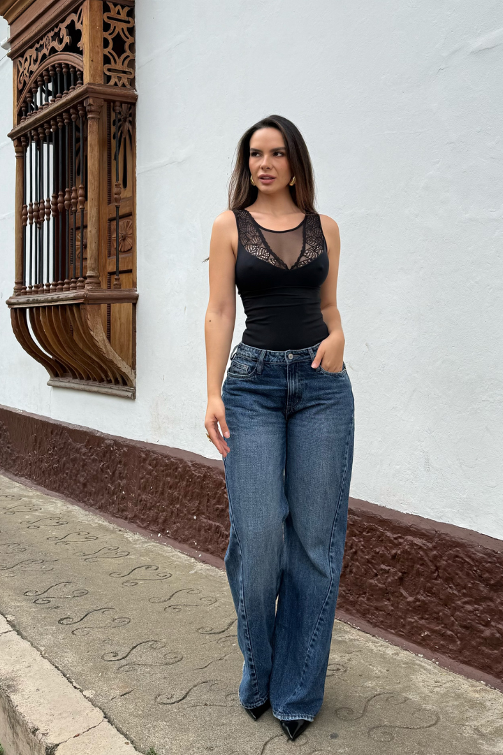 Body Aura negro de control de abdomen con detalles de encaje en el escote, combinado con jeans anchos.